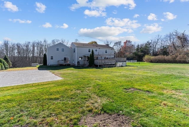 rear view of house featuring a deck and a lawn