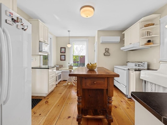 kitchen with dark countertops, open shelves, light wood-type flooring, under cabinet range hood, and white appliances