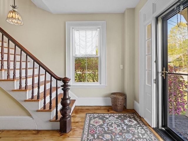 entrance foyer featuring plenty of natural light, stairs, baseboards, and wood finished floors