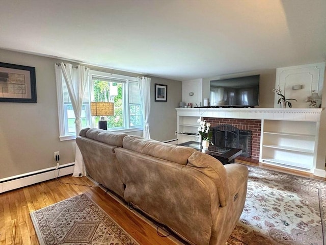 103 Sycamore St, Holbrook, MA 02343 - living area with hardwood / wood-style flooring, a brick fireplace, a baseboard radiator, and baseboards