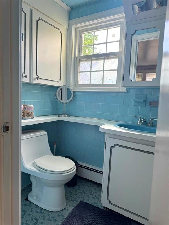 103 Sycamore St, Holbrook, MA 02343 - bathroom with a baseboard radiator, vanity, toilet, and backsplash