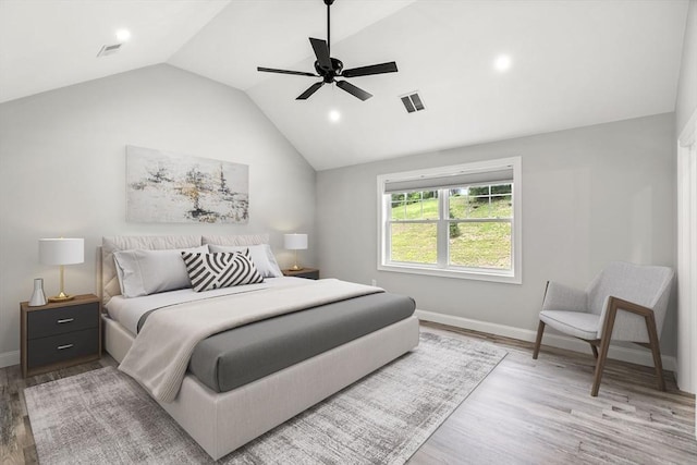 bedroom with lofted ceiling, visible vents, baseboards, and wood finished floors