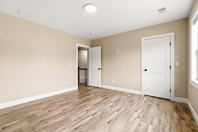 unfurnished bedroom featuring light wood-style floors, visible vents, and baseboards