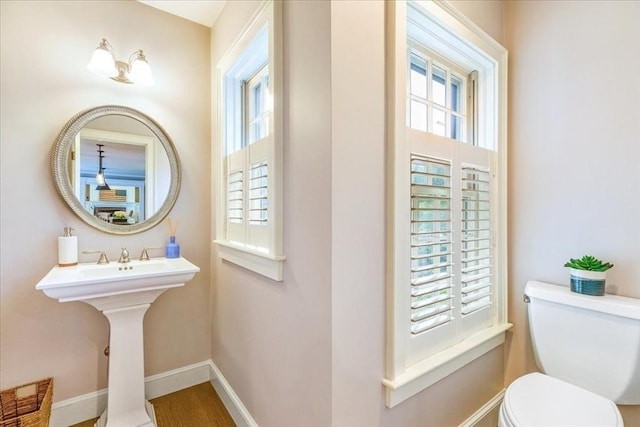 bathroom featuring toilet and baseboards