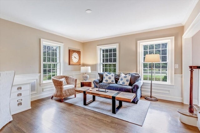 living room with wainscoting, crown molding, and wood finished floors
