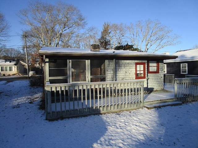 snow covered rear of property featuring a wooden deck