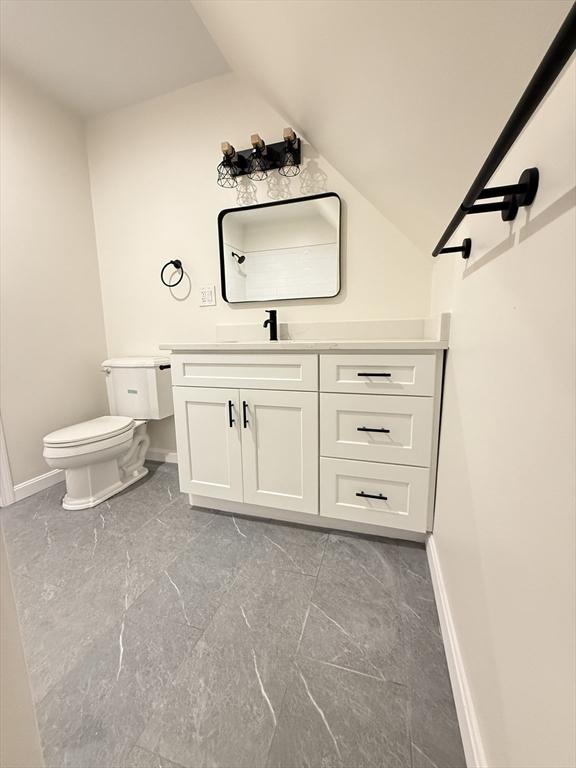 76 Garfield St, Quincy, MA 02169 - half bath featuring marble tiled floors, baseboards, vanity, and vaulted ceiling
