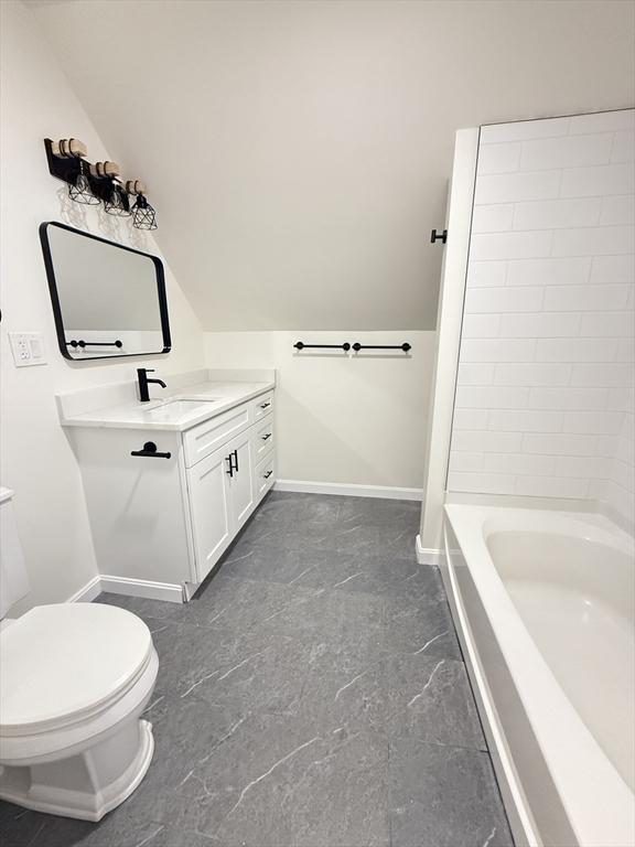 76 Garfield St, Quincy, MA 02169 - bathroom featuring vanity, toilet, baseboards, and vaulted ceiling