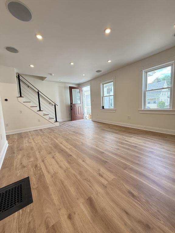 76 Garfield St, Quincy, MA 02169 - unfurnished living room with baseboards, stairs, light wood-style floors, and recessed lighting