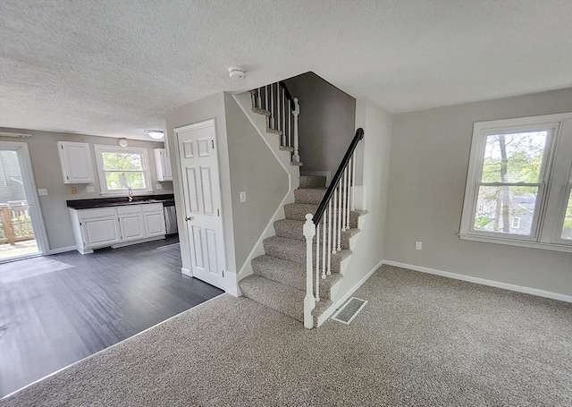 31 Harvard Ct, Dracut, MA 01826 - staircase featuring baseboards, a textured ceiling, wood finished floors, and carpet floors