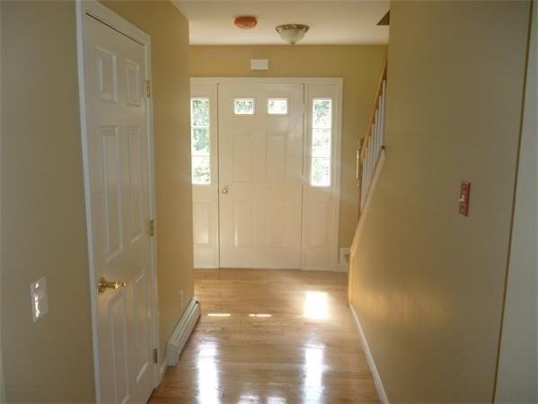 97 N Row Rd, Sterling, MA 01564 - foyer featuring a baseboard heating unit, light wood-style flooring, and stairs