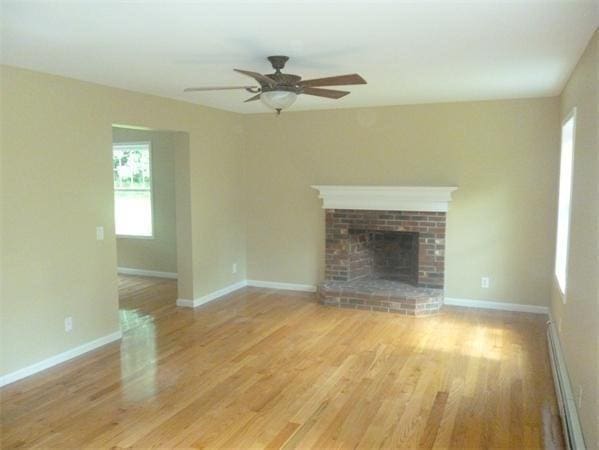 97 N Row Rd, Sterling, MA 01564 - unfurnished living room with a baseboard radiator, wood finished floors, and ceiling fan