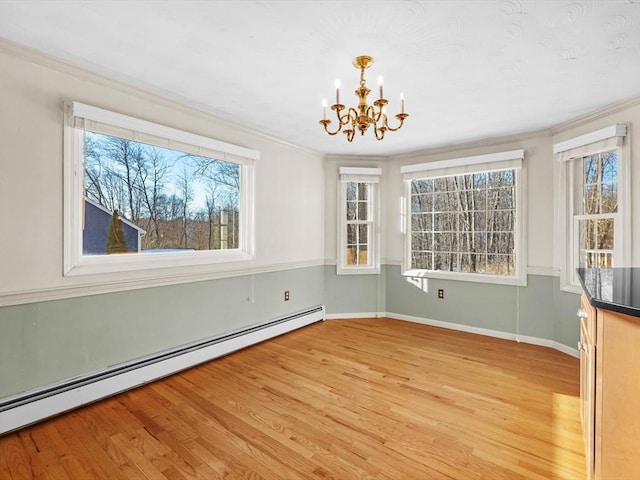 unfurnished dining area with a notable chandelier, crown molding, light hardwood / wood-style floors, and a baseboard radiator