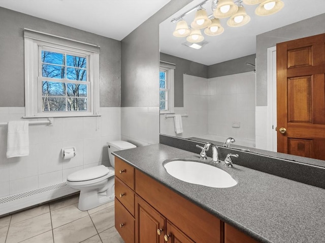 bathroom featuring baseboard heating, tile patterned flooring, vanity, tile walls, and toilet