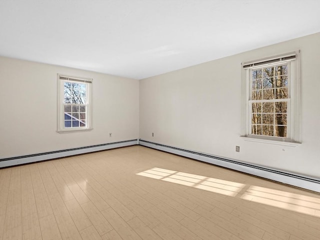 spare room featuring a baseboard radiator and light wood-type flooring