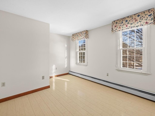 spare room with light wood-type flooring and a baseboard radiator