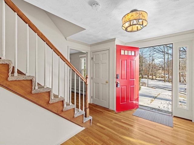 entrance foyer featuring crown molding, light hardwood / wood-style flooring, and a baseboard radiator