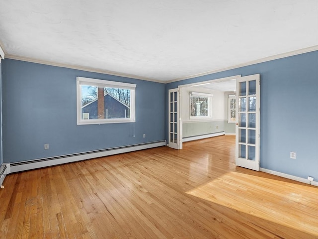 unfurnished room featuring a baseboard heating unit, ornamental molding, light hardwood / wood-style floors, and plenty of natural light