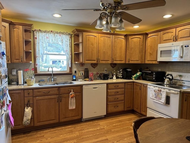 kitchen with white appliances, light countertops, light wood-style floors, open shelves, and a sink