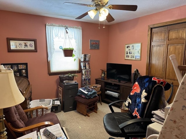 office featuring a ceiling fan and light carpet