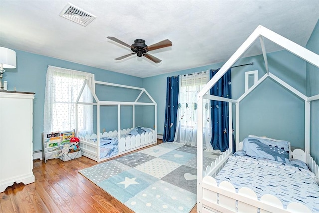 11 Balmoral Dr, Methuen, MA 01844 - bedroom with wood finished floors, a baseboard radiator, baseboards, and a ceiling fan