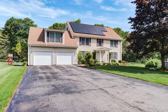 11 Balmoral Dr, Methuen, MA 01844 - colonial house featuring asphalt driveway, roof mounted solar panels, a front yard, and a playground