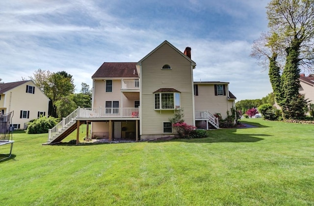 11 Balmoral Dr, Methuen, MA 01844 - back of house featuring a trampoline, stairway, a chimney, a lawn, and a deck