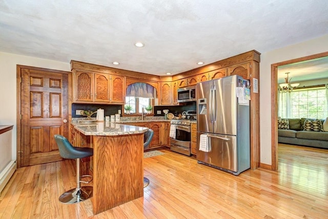 11 Balmoral Dr, Methuen, MA 01844 - kitchen featuring stainless steel appliances, brown cabinets, light wood-type flooring, baseboards, and recessed lighting