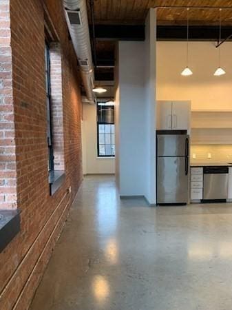 160 Water St Unit 212, Williamstown, MA 01267 - hallway featuring brick wall, a towering ceiling, and wooden ceiling