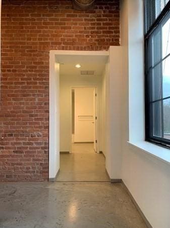 160 Water St Unit 212, Williamstown, MA 01267 - hallway featuring brick wall, baseboards, and speckled floor