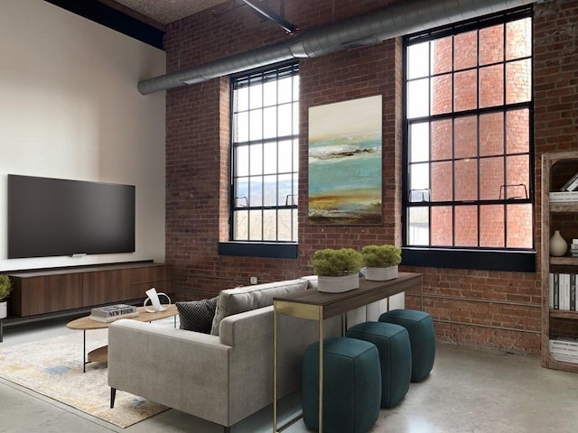 160 Water St Unit 212, Williamstown, MA 01267 - living room with brick wall, finished concrete flooring, healthy amount of natural light, and a towering ceiling