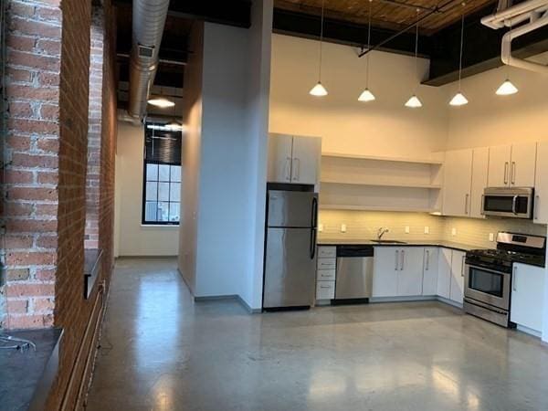 160 Water St Unit 212, Williamstown, MA 01267 - kitchen with stainless steel appliances, a towering ceiling, open shelves, backsplash, and a sink