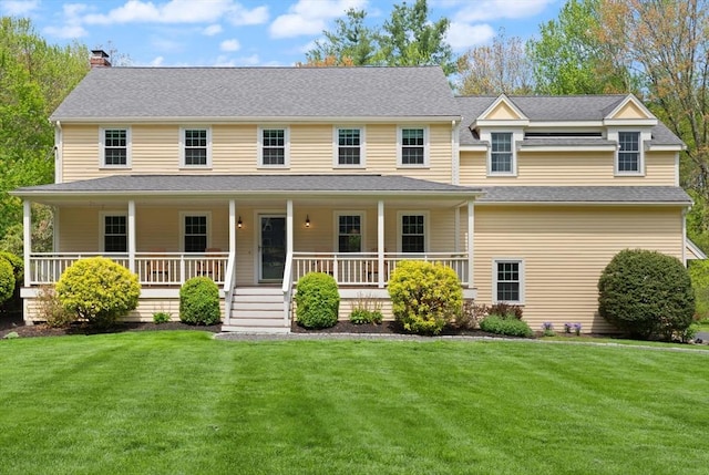view of front of home featuring a chimney, a front yard, covered porch, and a shingled roof