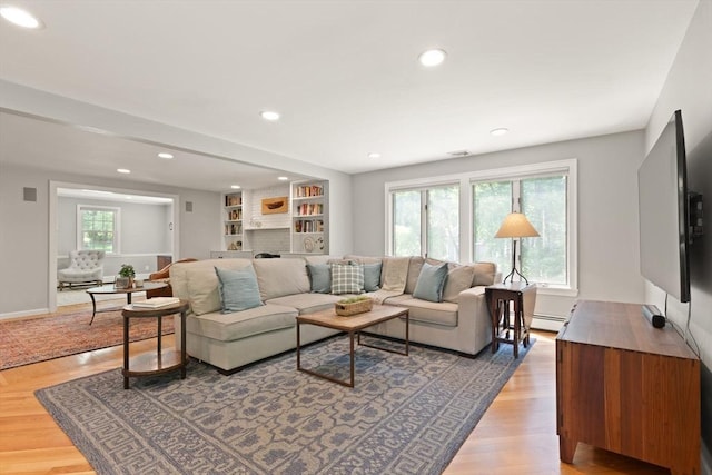 living room featuring recessed lighting, a baseboard radiator, and baseboards