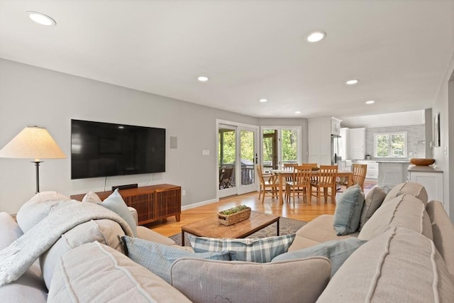 living area with light wood finished floors, recessed lighting, and baseboards