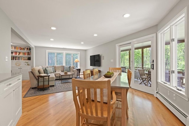 dining space featuring a baseboard radiator, light wood-style flooring, and recessed lighting