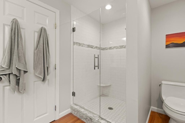 full bathroom with baseboards, wood finished floors, a stall shower, and recessed lighting