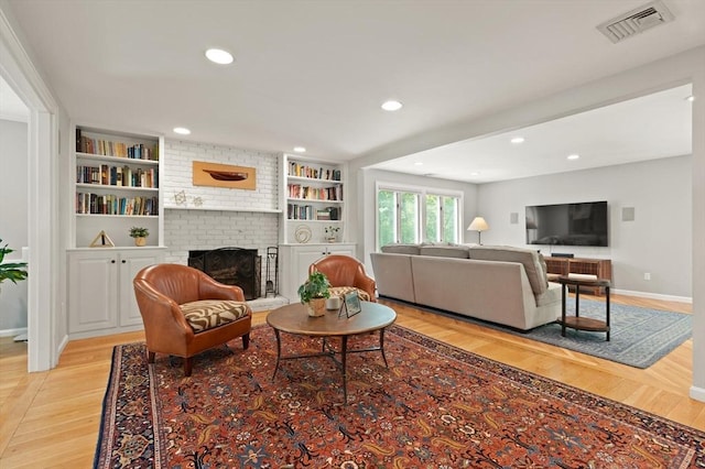 living room with light wood-style flooring, a brick fireplace, baseboards, recessed lighting, and built in shelves