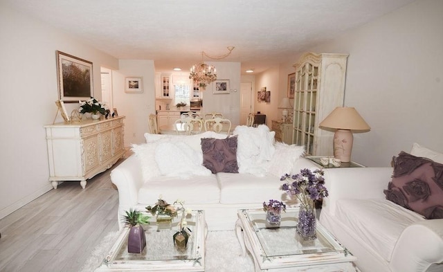 living room with light hardwood / wood-style flooring and a notable chandelier