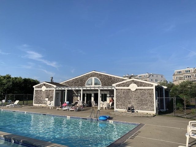 rear view of property with a patio and a community pool