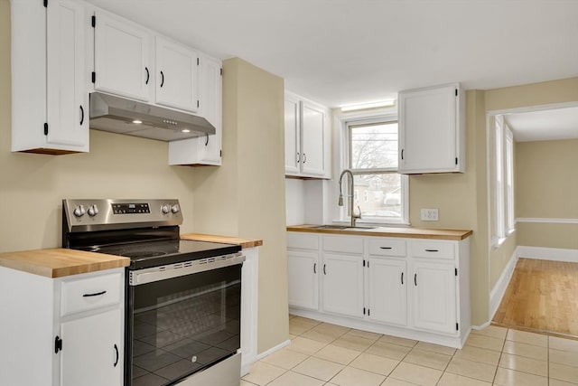 kitchen featuring light tile patterned floors, electric range, white cabinetry, a sink, and under cabinet range hood