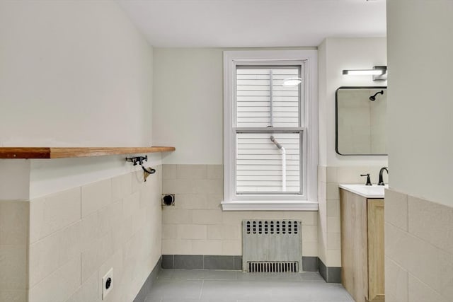 full bathroom with radiator, wainscoting, tile walls, and vanity