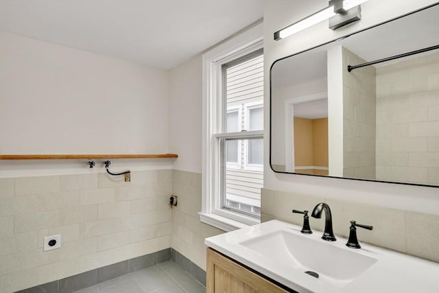 bathroom featuring wainscoting, tile walls, and vanity