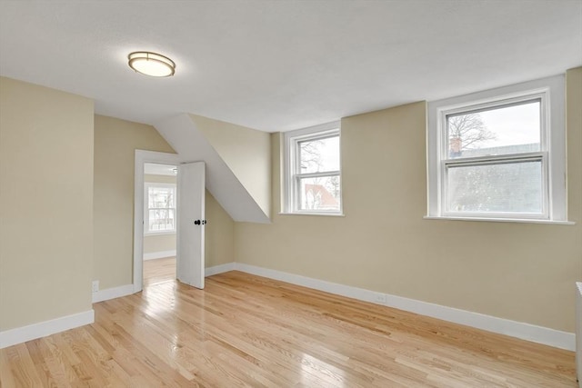 bonus room featuring light wood-style floors and baseboards