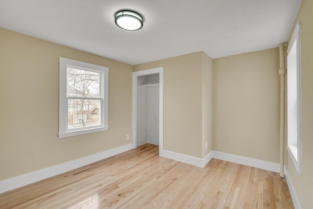 unfurnished bedroom featuring a closet, baseboards, and wood finished floors