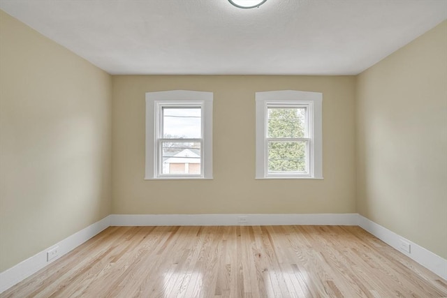 spare room featuring wood finished floors and baseboards