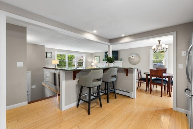 13 Shagbark Rd, Sandwich, MA 02644 - kitchen featuring a chandelier, a breakfast bar, light wood-style flooring, dark stone countertops, and recessed lighting