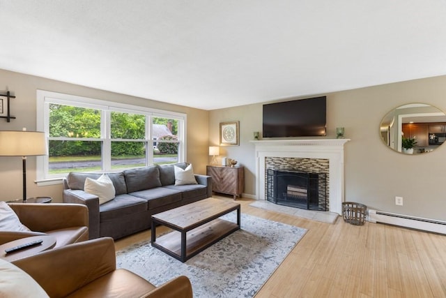 13 Shagbark Rd, Sandwich, MA 02644 - living room with healthy amount of natural light, a baseboard heating unit, a stone fireplace, and wood finished floors