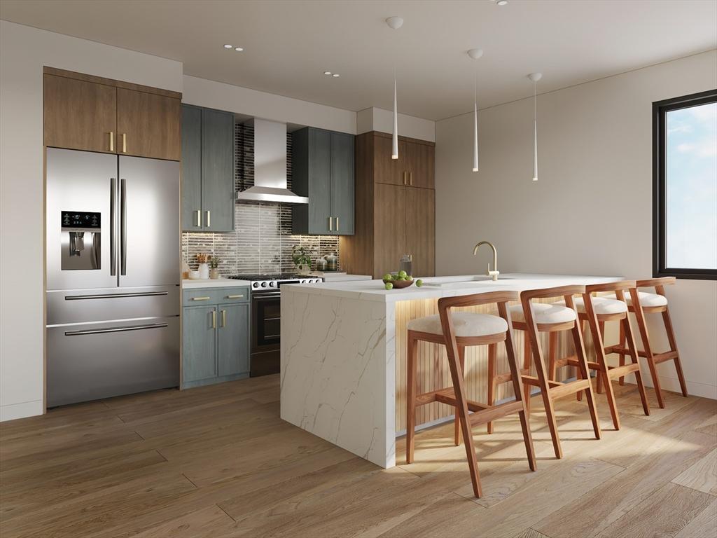 kitchen featuring a kitchen bar, light wood-type flooring, wall chimney exhaust hood, appliances with stainless steel finishes, and backsplash