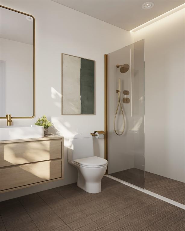 bathroom featuring vanity, a walk in shower, and toilet